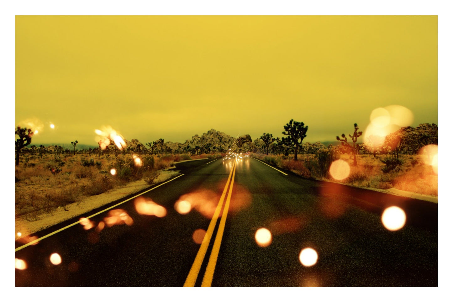 Fine art photography of double yellow lines on a desert road in Joshua Tree, architectural vanishing point, warm horizon with digital light artifacts, cinematic western landscape.
